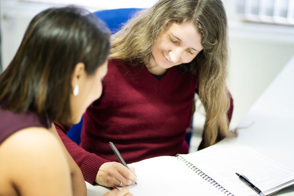 Zwei Frauen sitzen an einem Schreibtisch